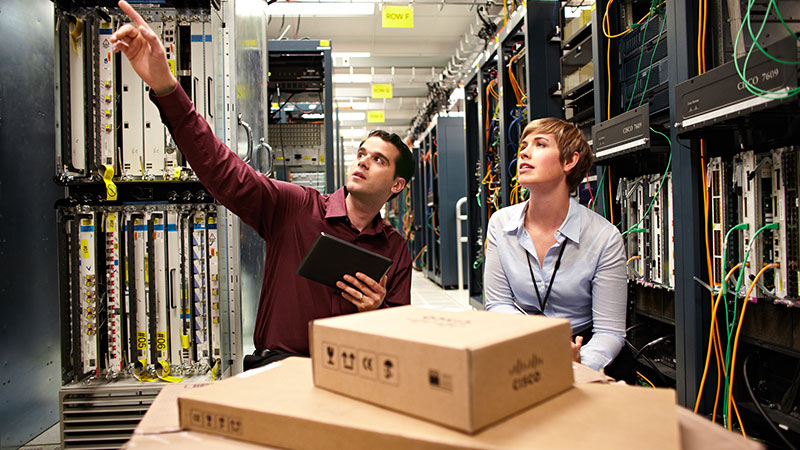 Two data center architects engaged in a discussion in the data center