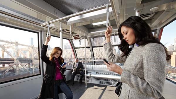 列車の中で吊り革につかまっている女性 2 人