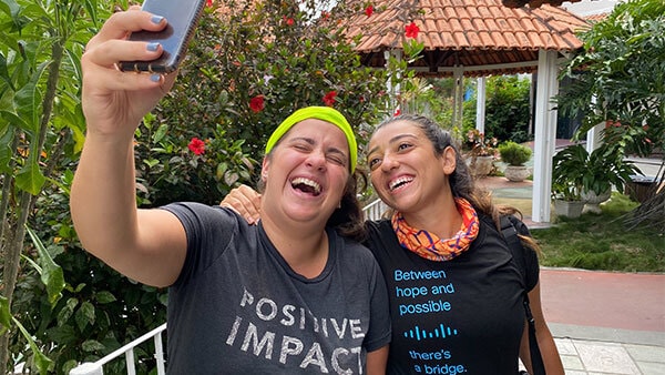 Two females taking a selife, laughing and smiling as they are on a giving back trip in Brazil