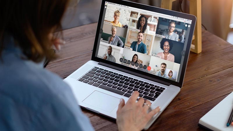A manager collaborates with her team remotely through a Webex video conference