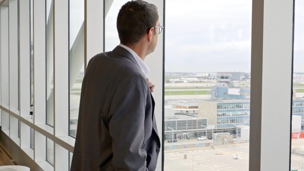 Man looking out window over Montreal Airport