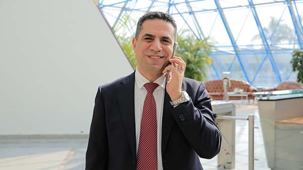 Mohamed of Telecom Egypt on phone smiling at camera