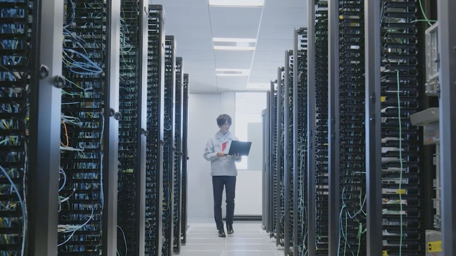 Man in server room holding a laptop