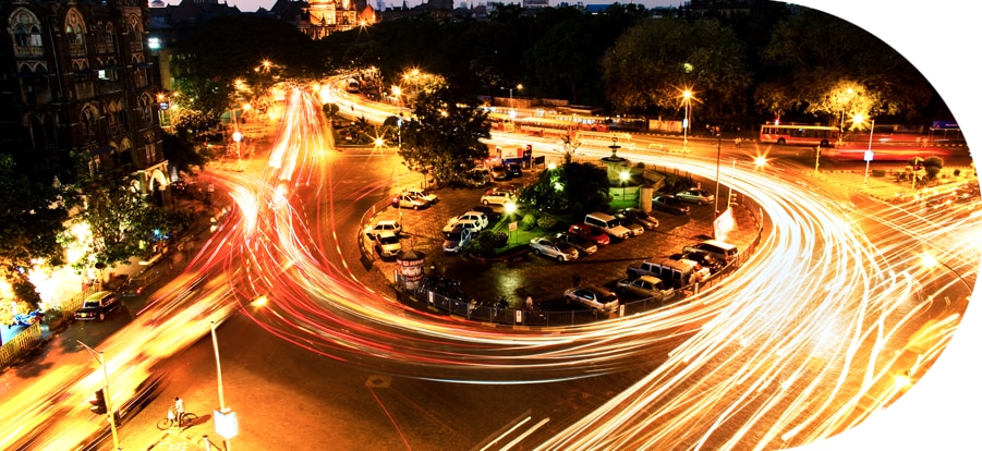 Trailing lights of vehicles moving through a city center 