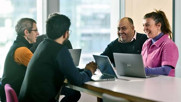 Colleagues chatting at a table in the office