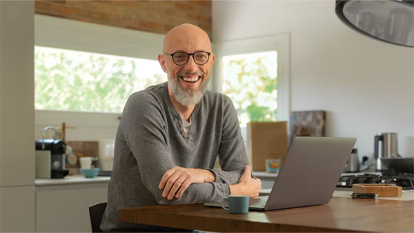 Person at desk smiling at camera