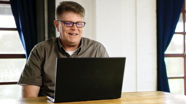Man working and smiling at laptop