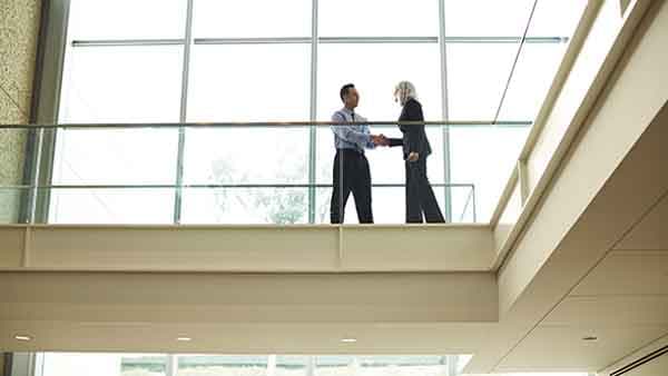 Businessman and businesswoman shake hands in an office building