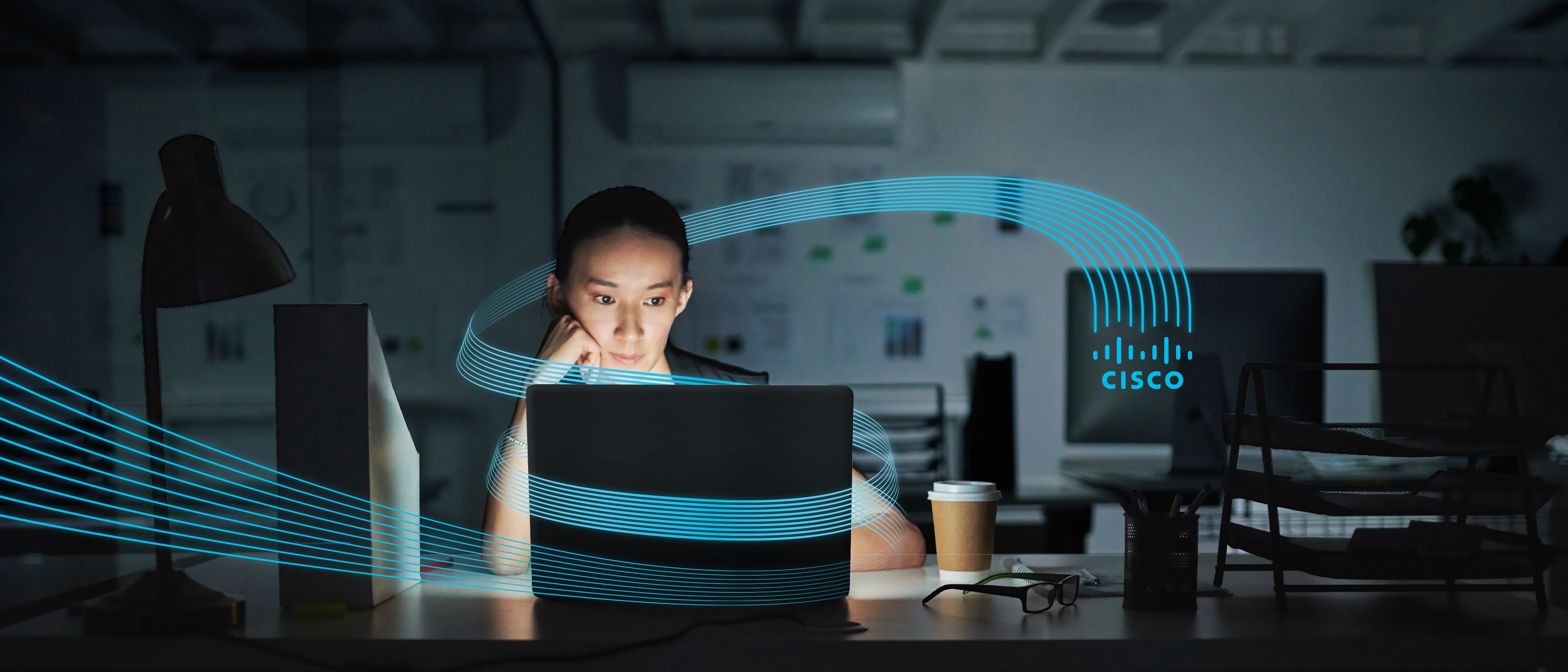 Woman facing forward at glowing laptop with dark background and Cisco logo tines wrapping image.