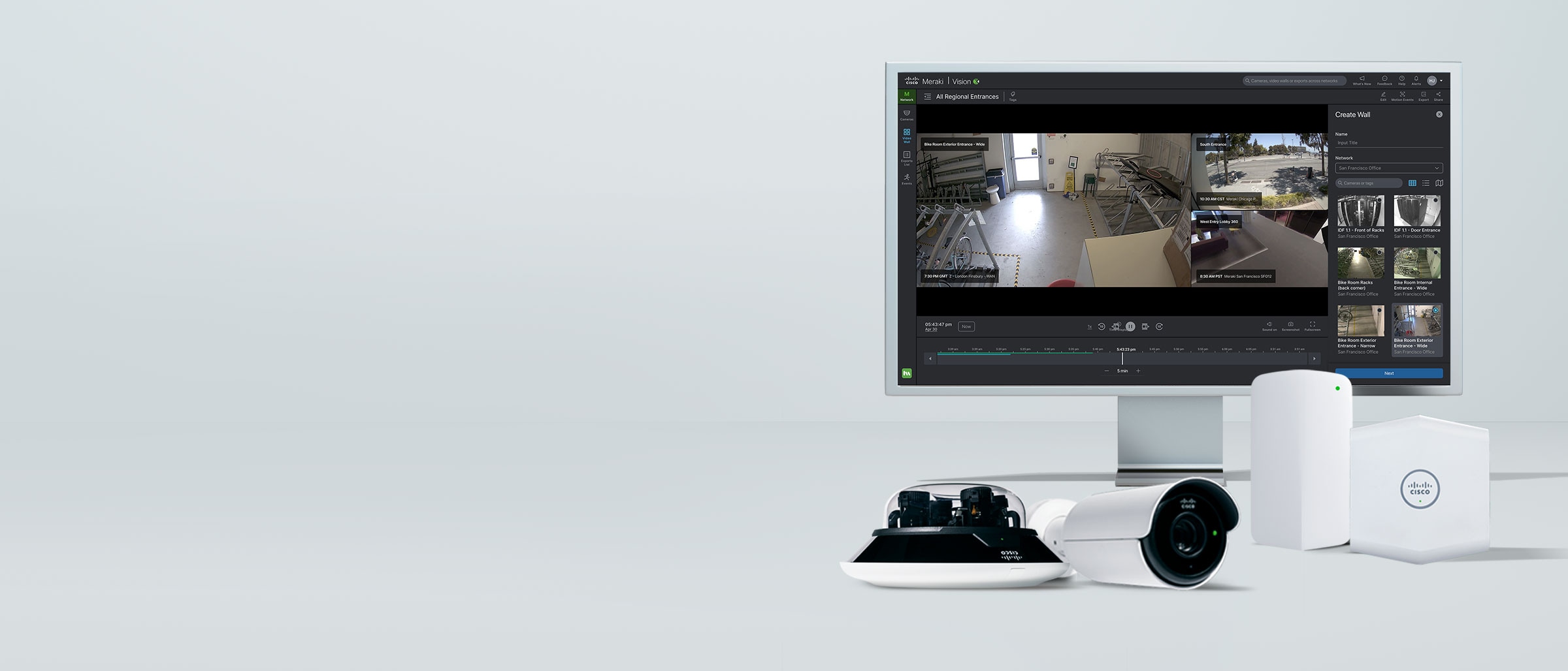 A monitor displaying a dashboard view from the Meraki Vision Portal displaying views from security cameras. In front of the display is Meraki security equipment, including a bullet camera, a multi-imager camera, a temperature and humidity sensor, and an air and CO2 sensor.