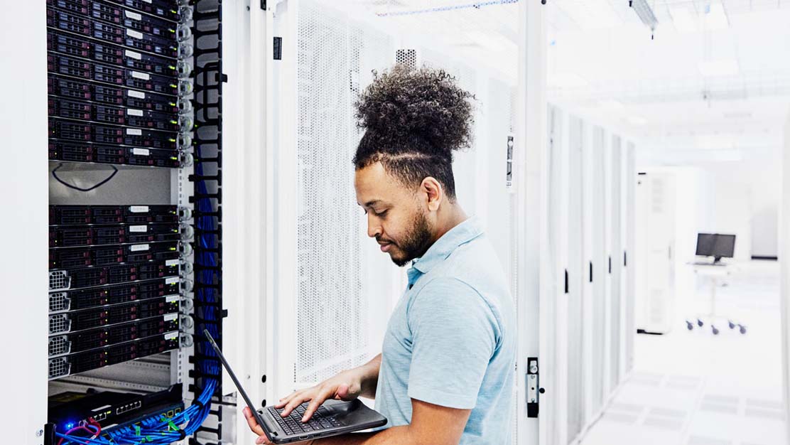 Mann, der vor einem Server-Rack steht