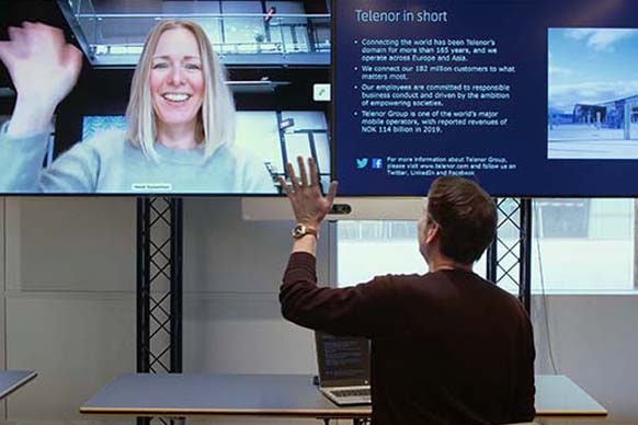 Two people having a virtual meeting in their respective workplaces using Cisco solutions