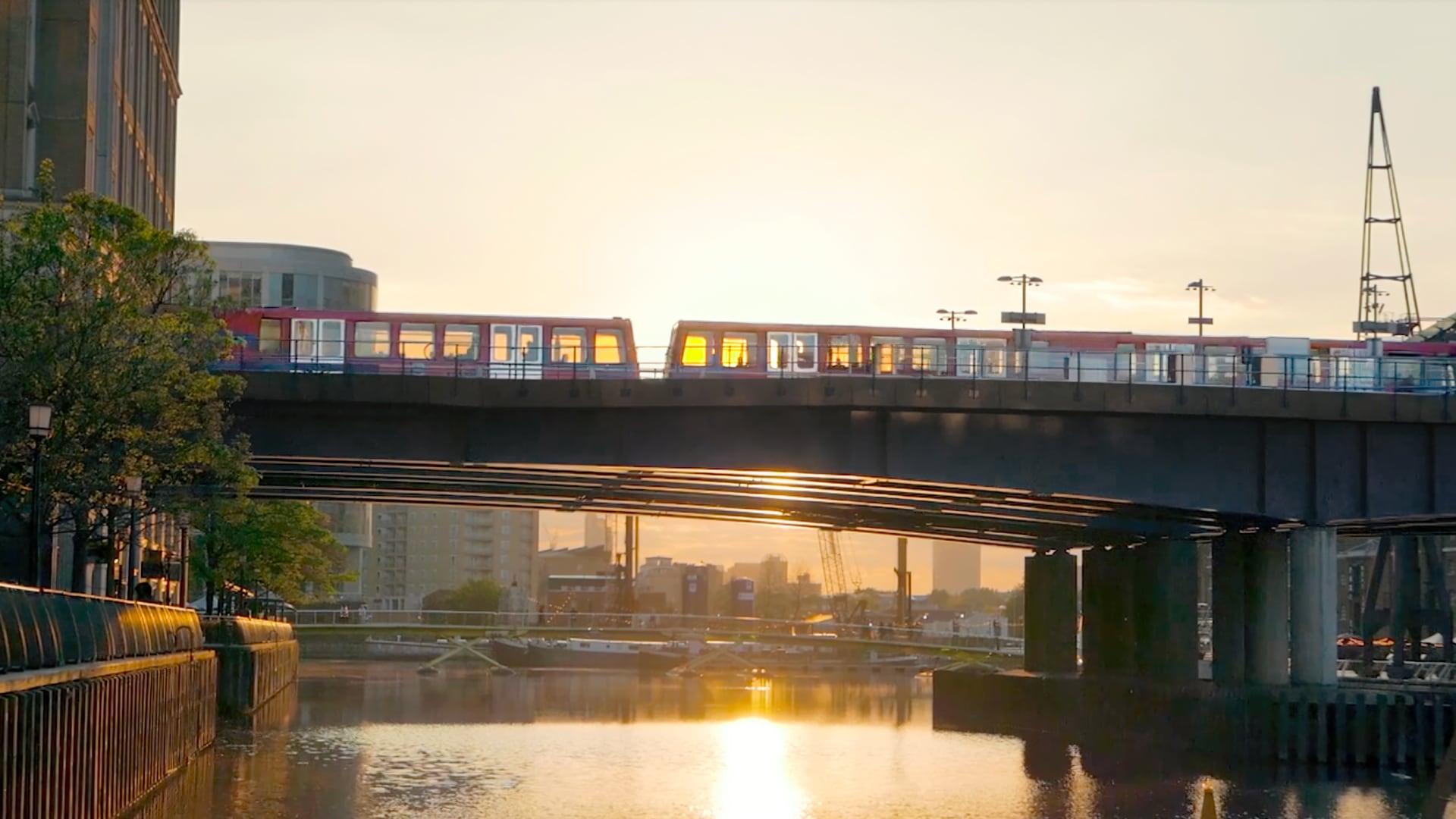 A train traveling over a bridge with a city skyline in the background