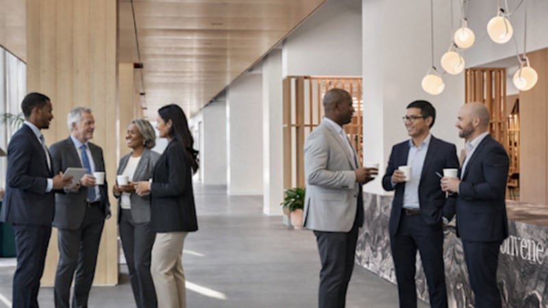 Employees chatting while holding coffee