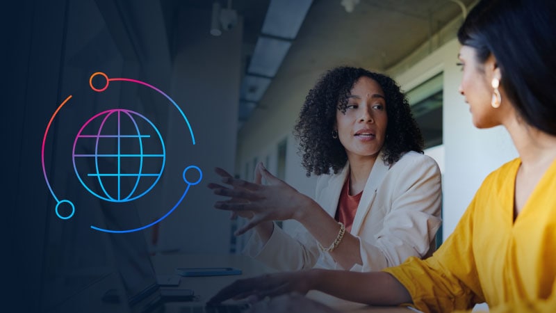 Two women in conversation with global icon to their left.