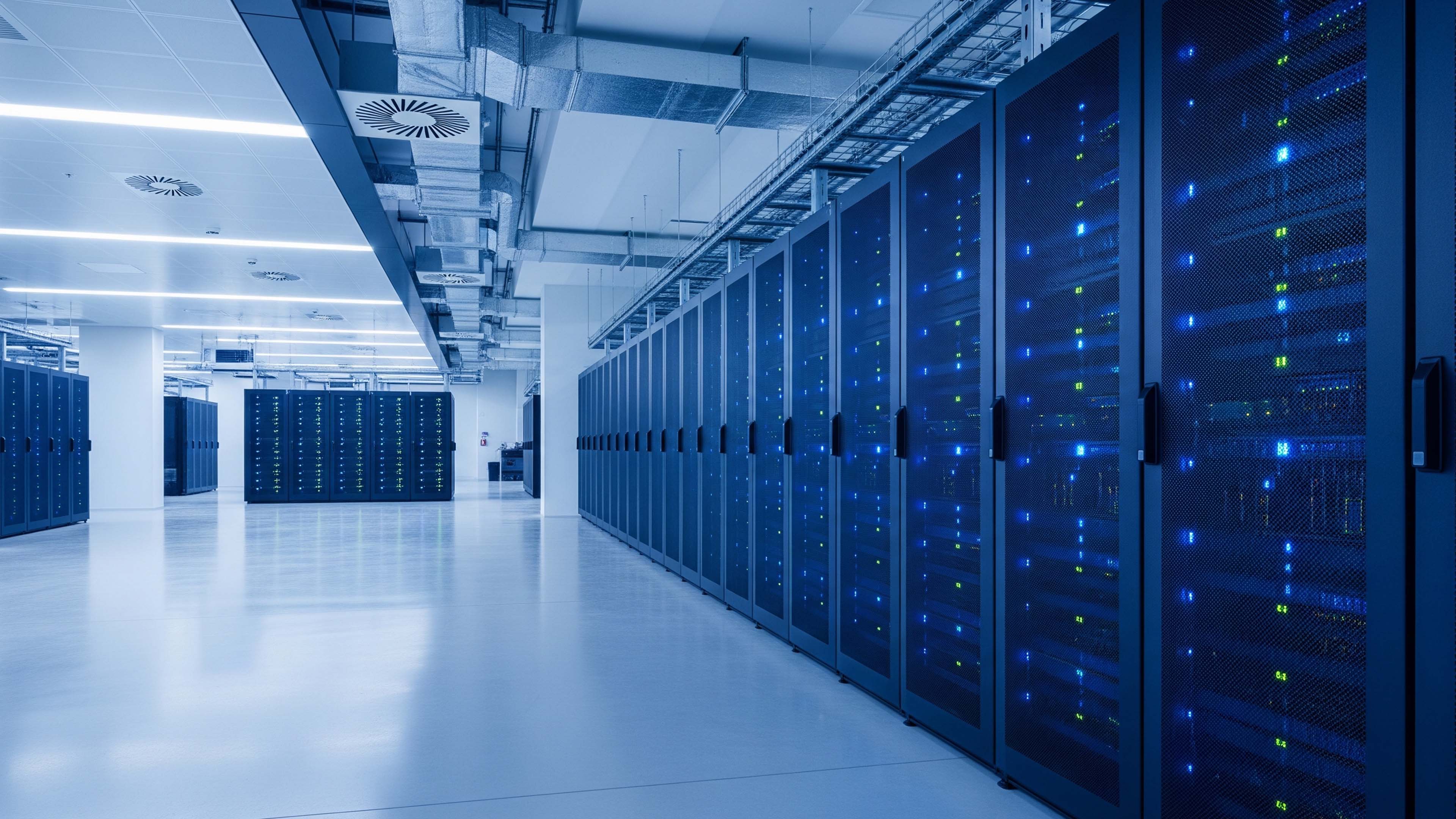 Rows of server racks in a modern data center with blue status lights.