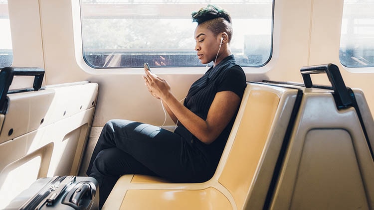 Young woman listening to music on train ride