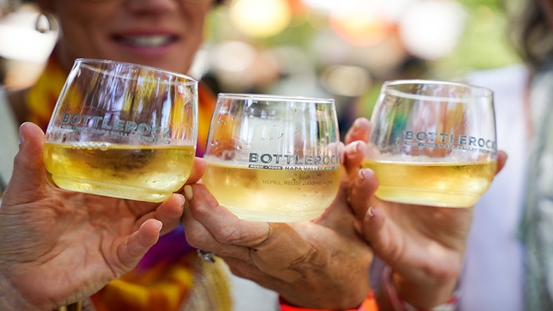 Three people holding up wine glasses at BottleRock.