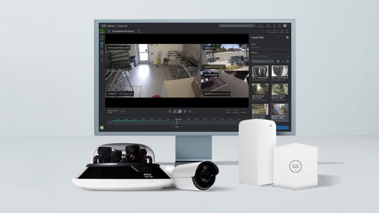 Meraki dashboard on a monitor next to Cisco Meraki physical security cameras and sensors.