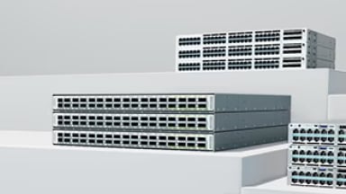 Stacked rack-mount network switches displayed on a tiered platform.