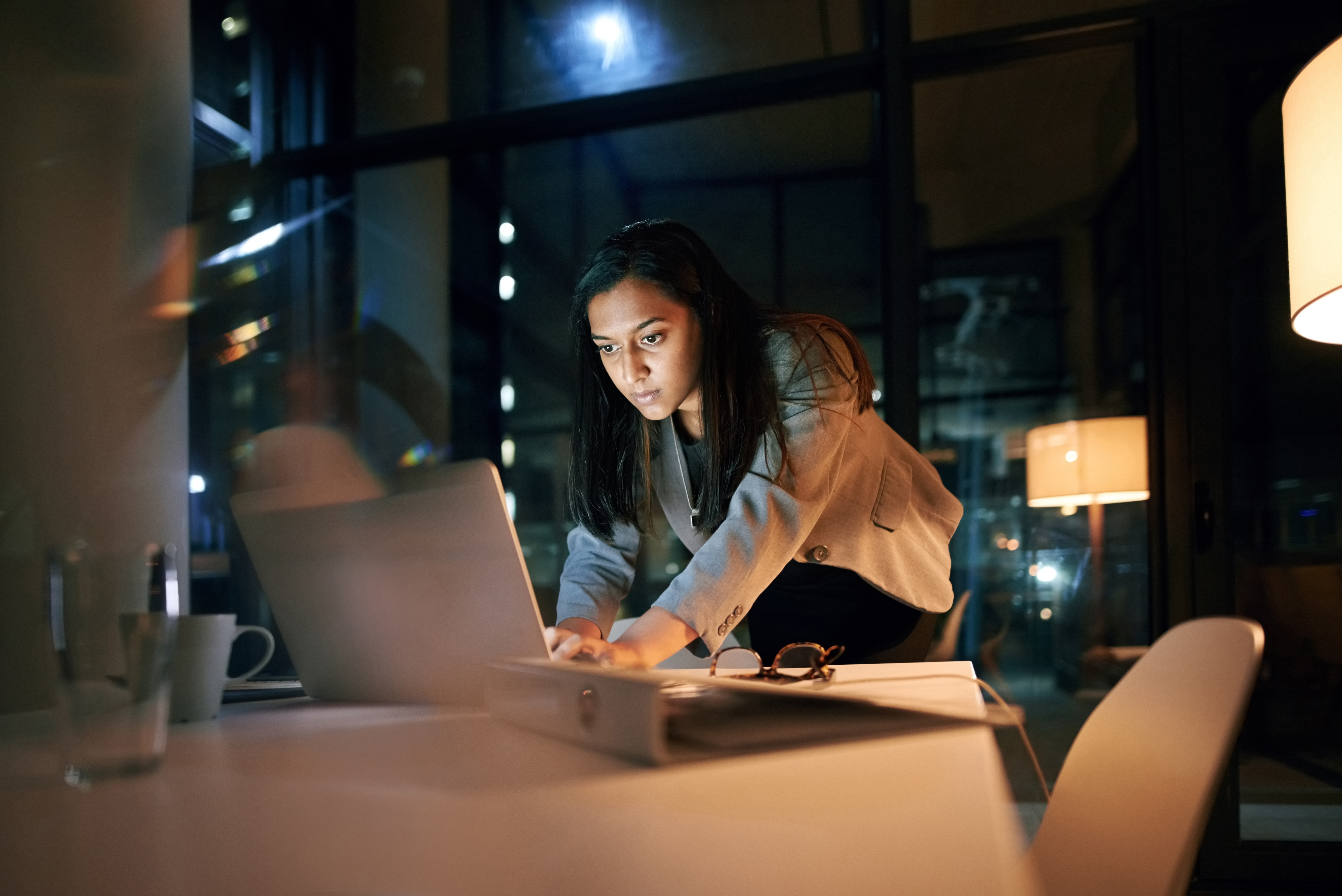 Persona che scrive al computer portatile stando in piedi a un tavolo da conferenze